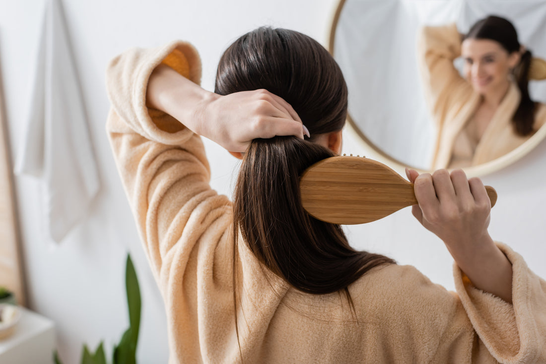 Woman brushing her hair in front of a mirror