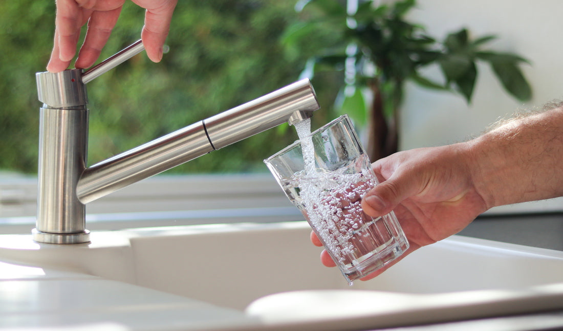 Filling a glass with water from a kitchen faucet