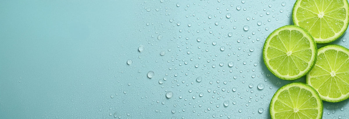 Lime slices on a light blue surface with water droplets