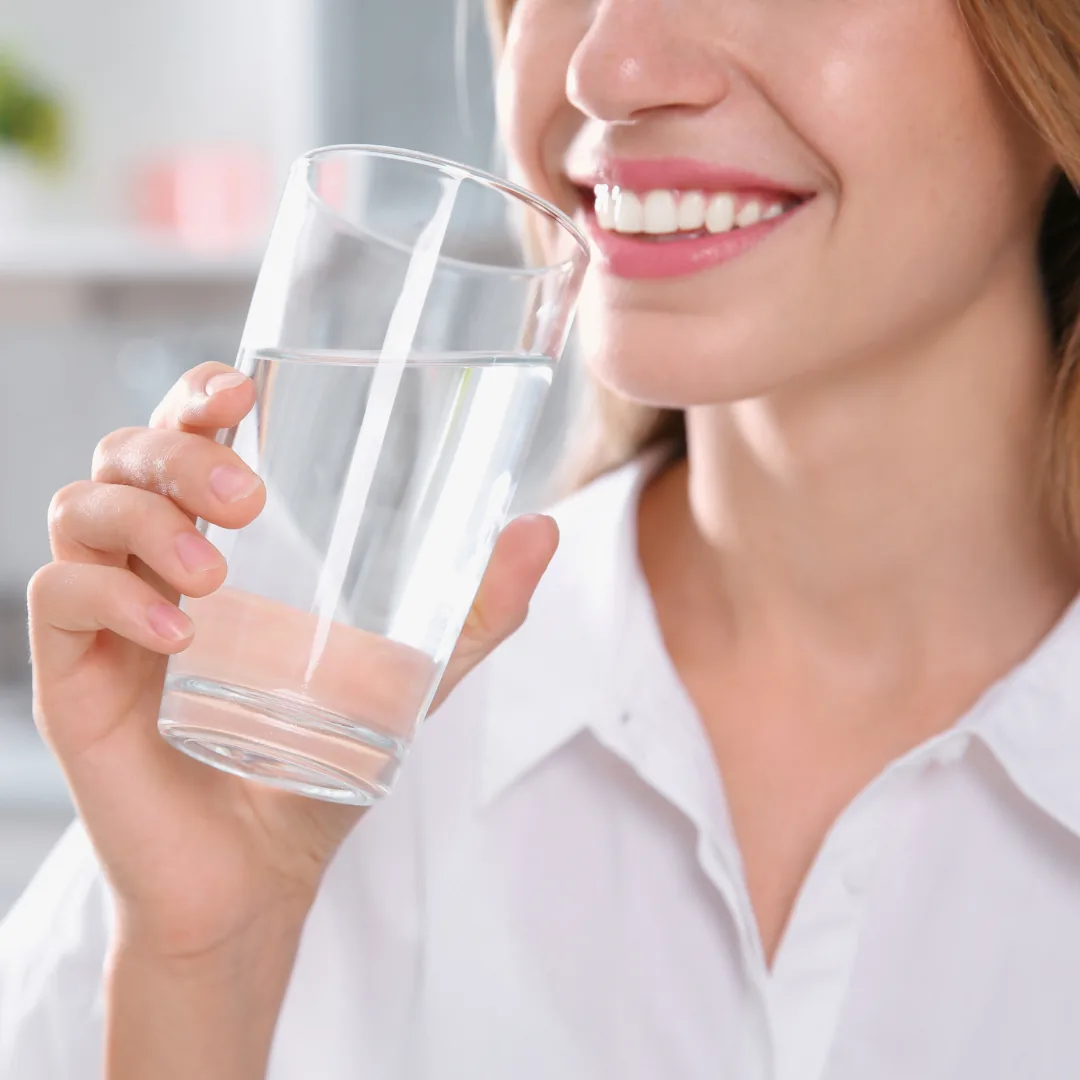 woman drinking soft, clean water from a clear glass