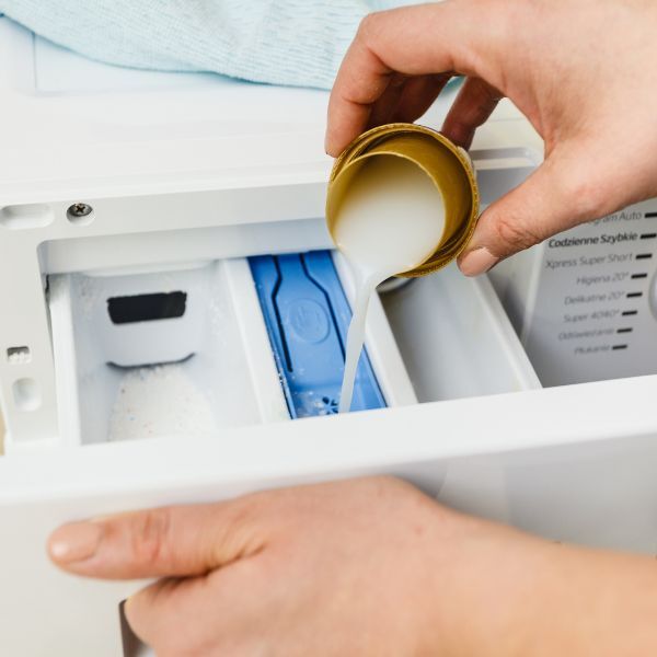 pouring detergent into a washer
