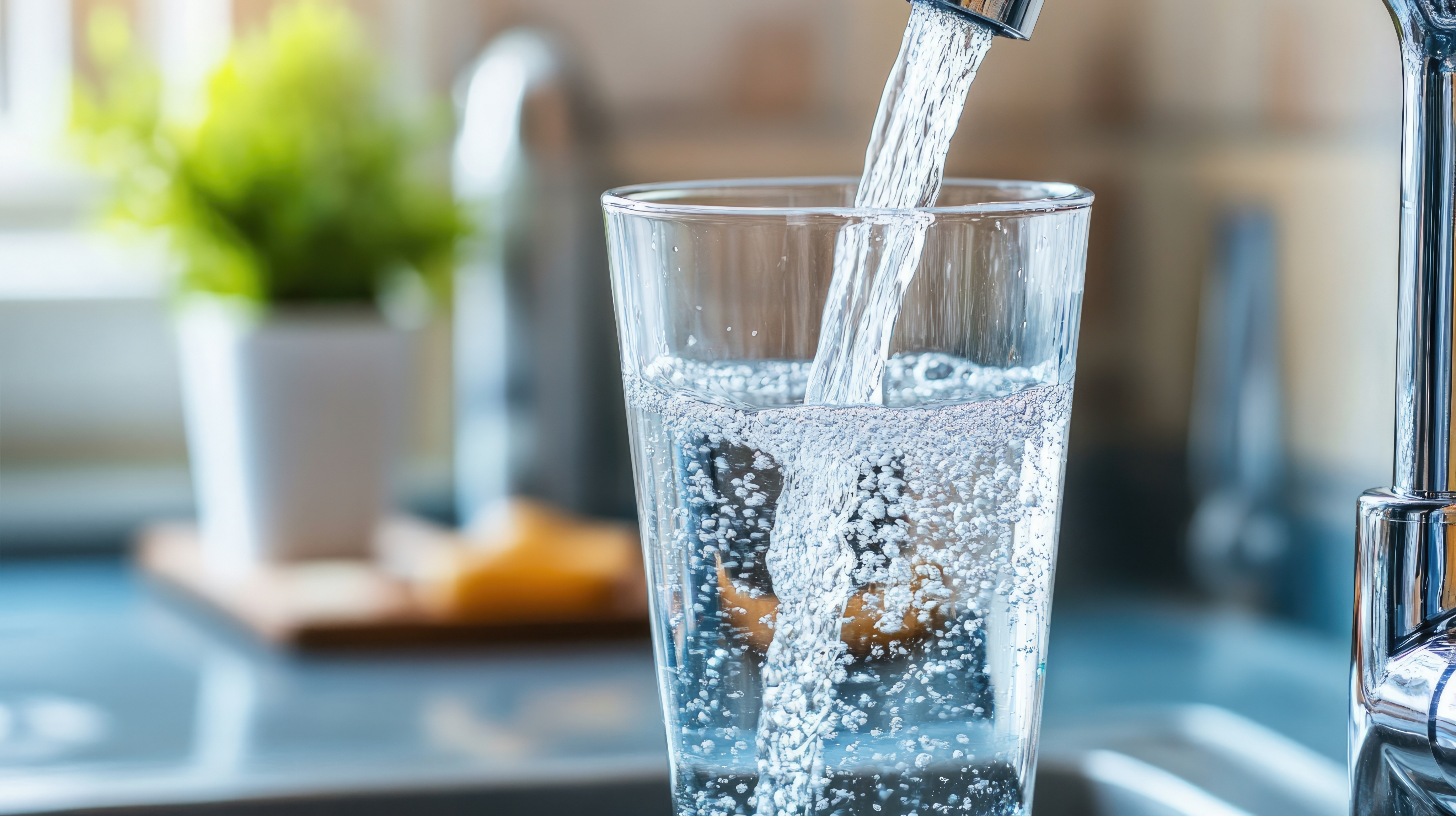 clean glass of water being poured from a faucet