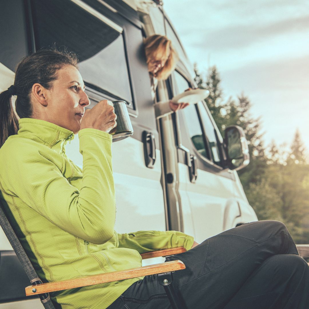 woman drinking water in front of RV