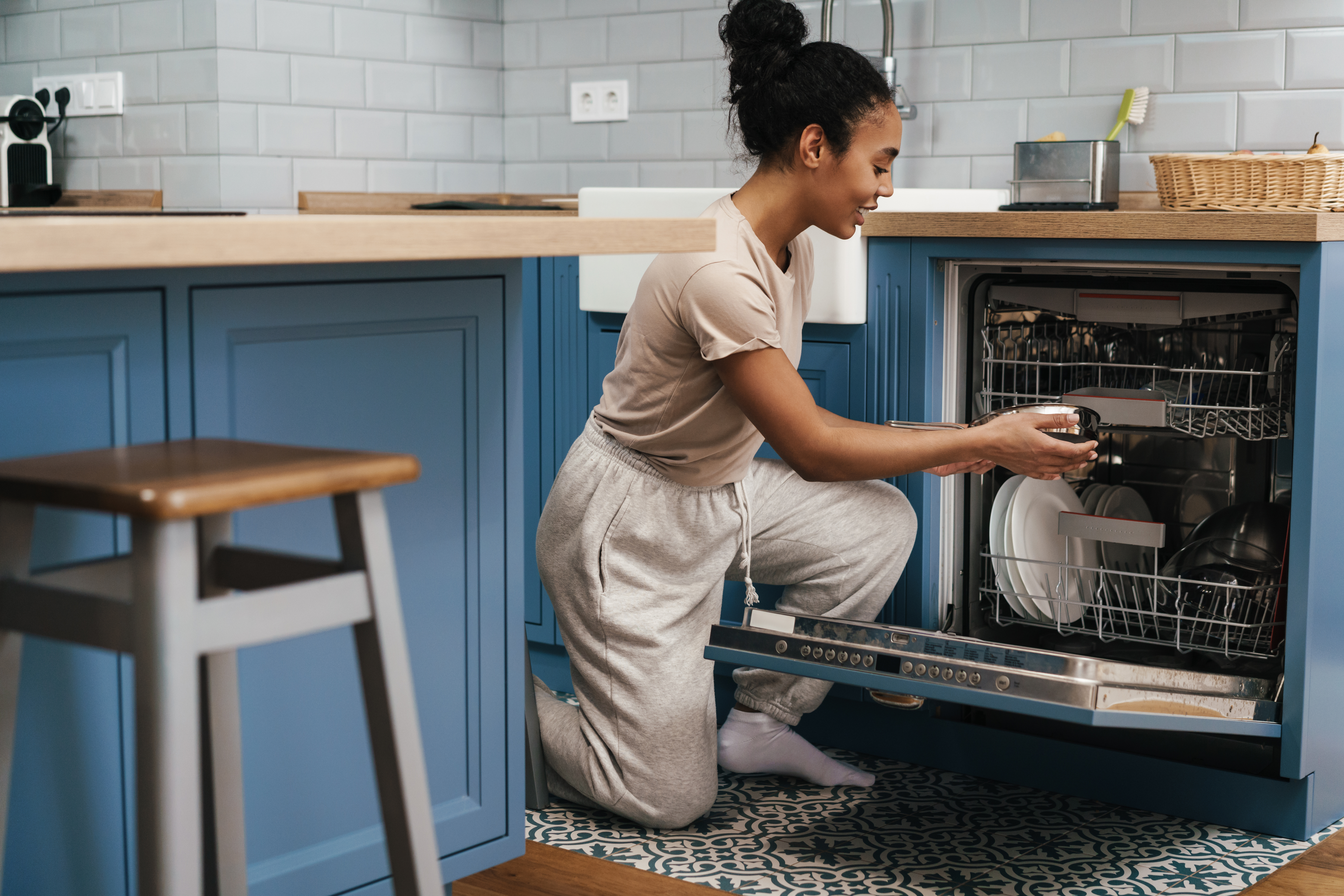 lady unloading clean dishes in her kitchen