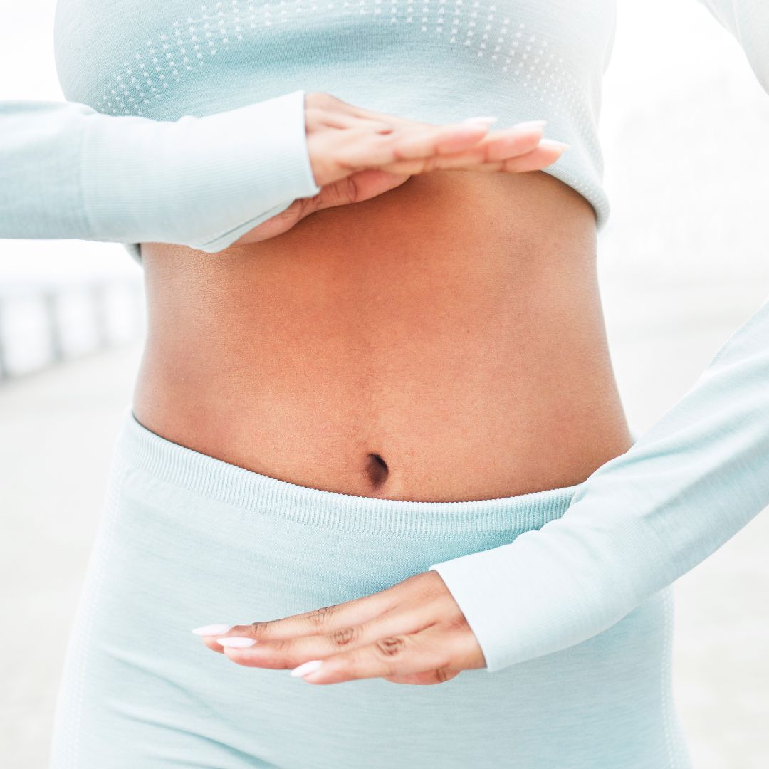 woman with hands around gut area