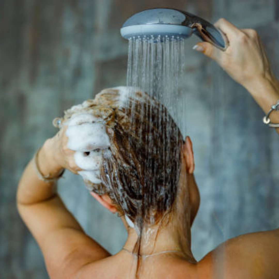 girl showering with hard water