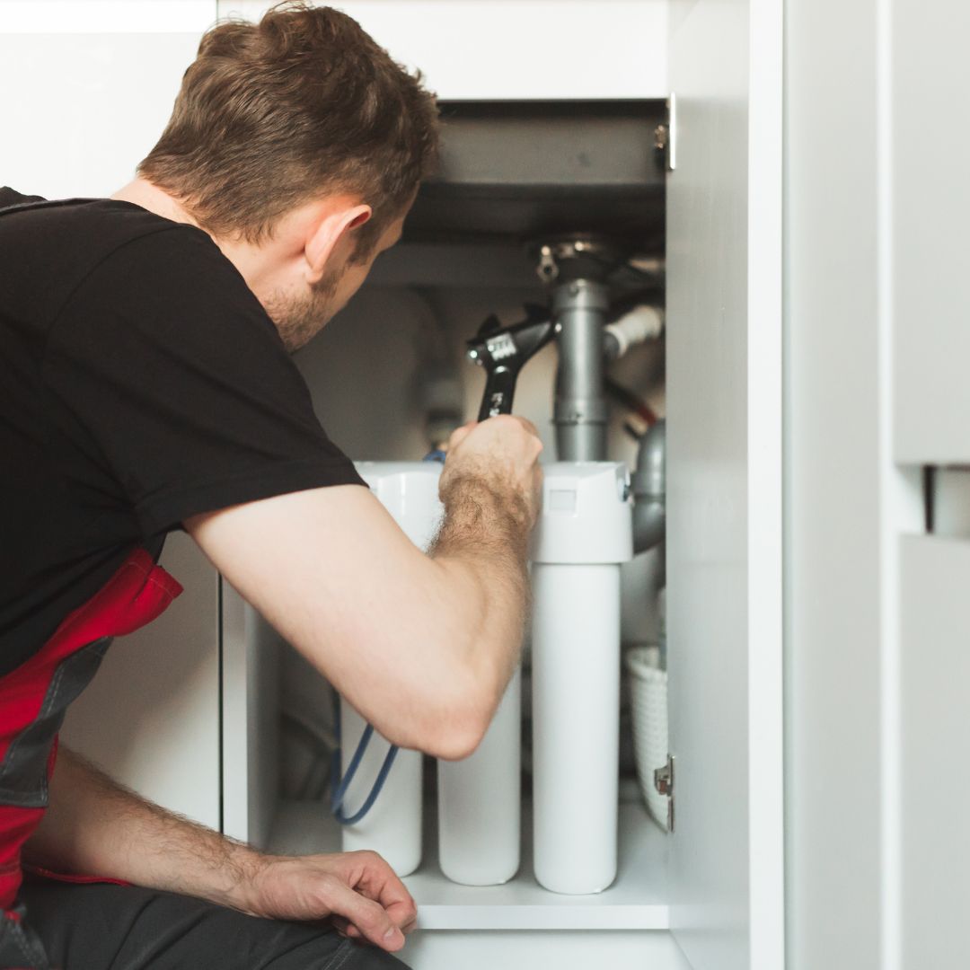 person working on water filter system