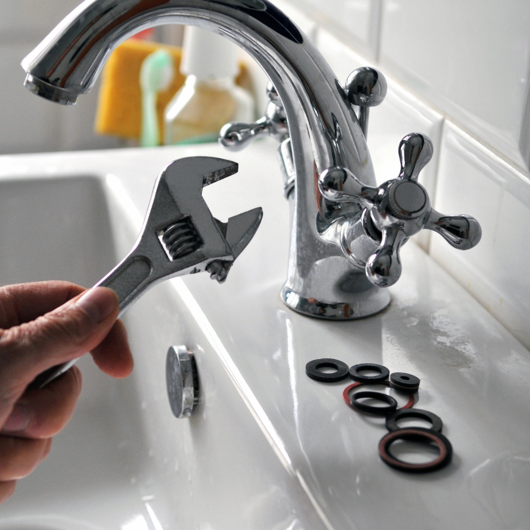 image of a faucet and a wrench