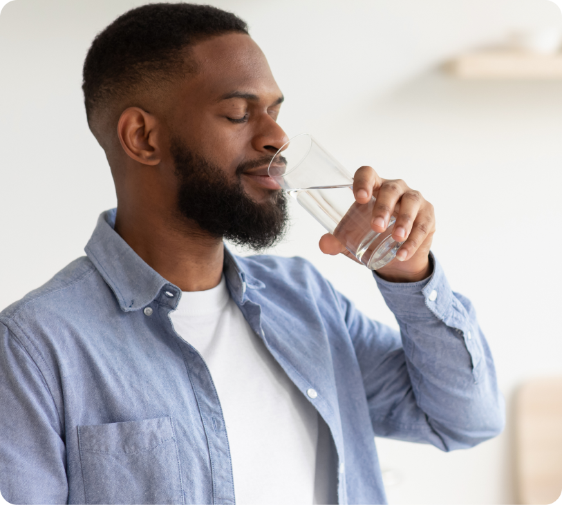 man drinking water from a glass at home