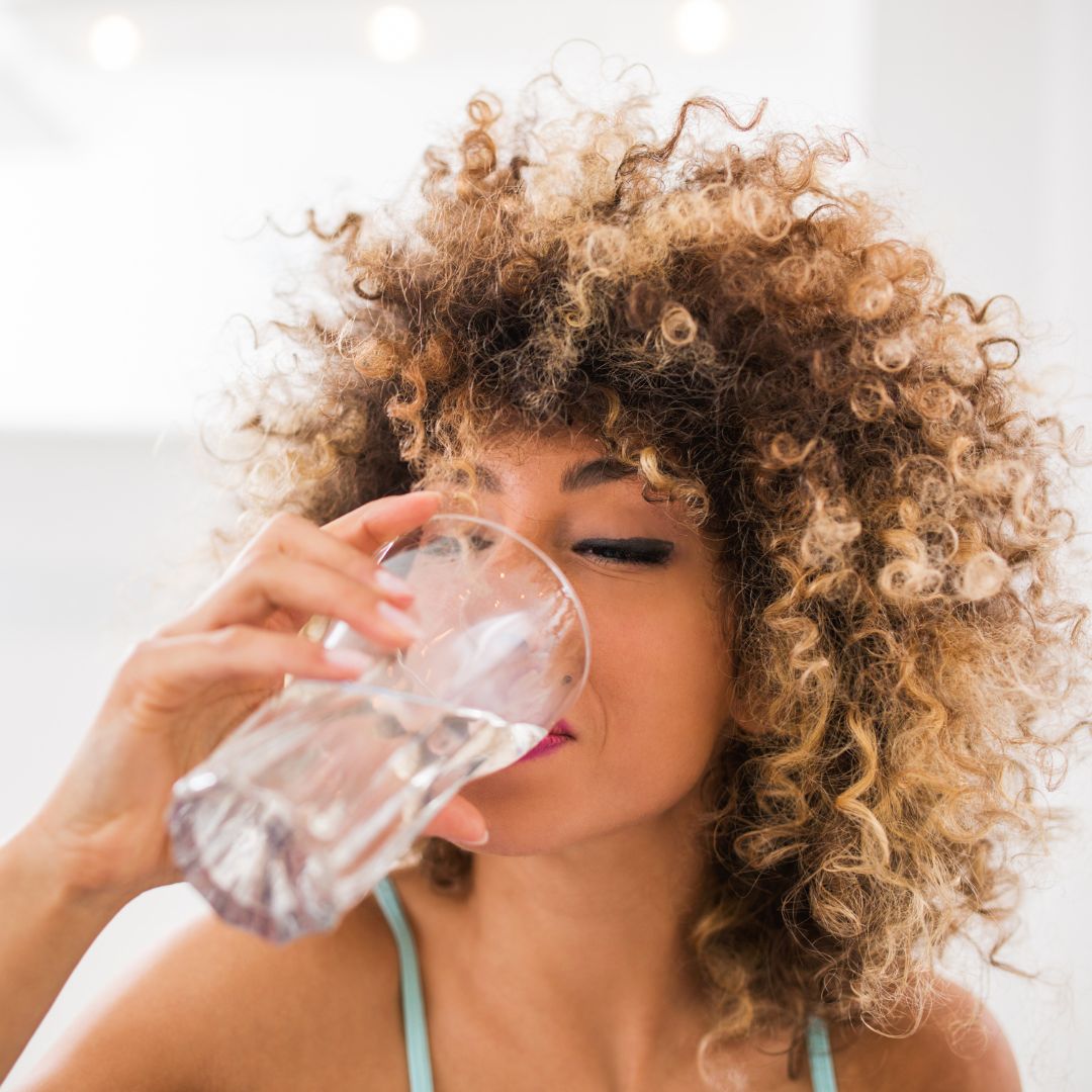 person drinking water out of glass